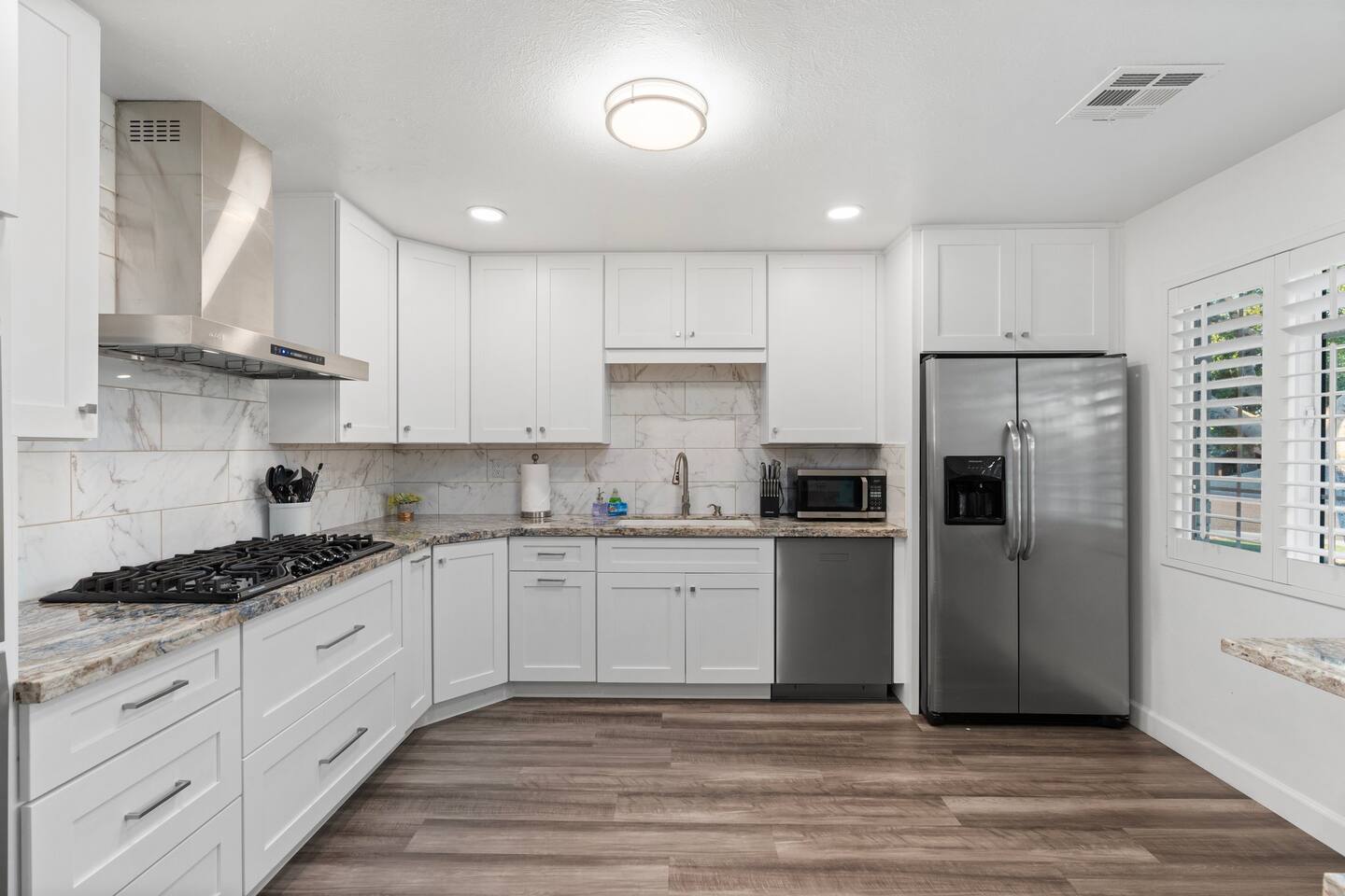 Cook like a pro in this sleek kitchen featuring stainless steel appliances, gas range, and ample granite counter space.

