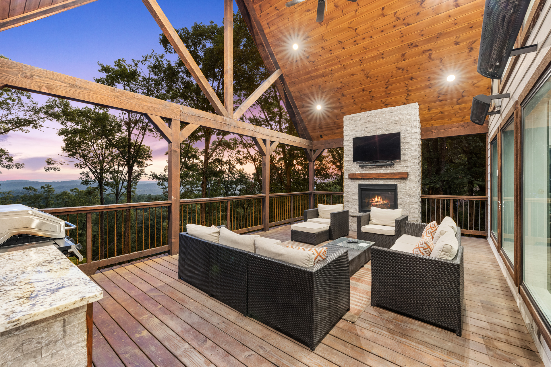 Luxury outdoor living area with fireplace, lounge seating, and panoramic views