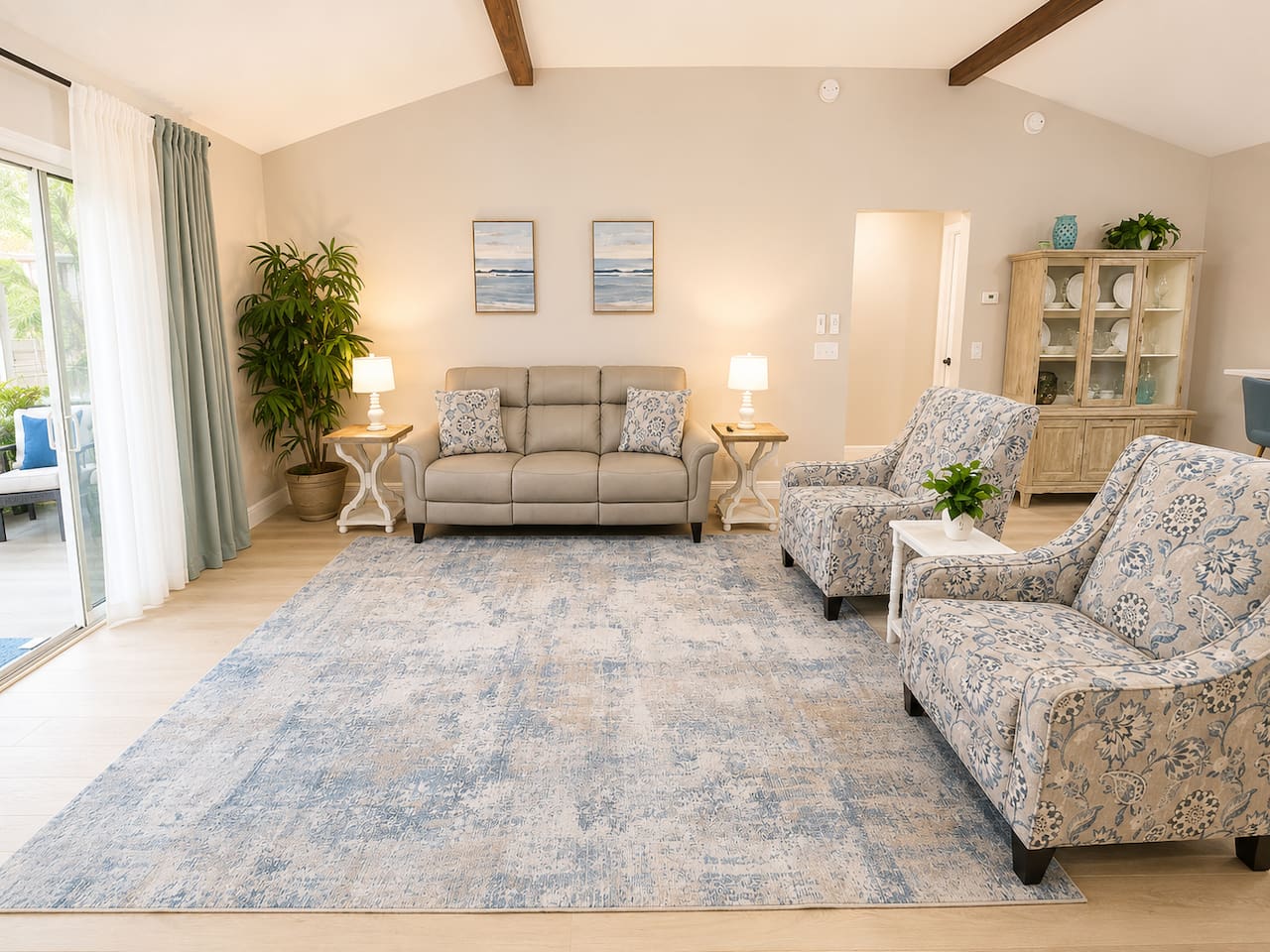 Relax beneath soaring vaulted ceilings with exposed wood beams in this bright, open living room featuring comfortable seating, stylish décor, and a large Smart TV—perfect for unwinding after a day in The Villages.