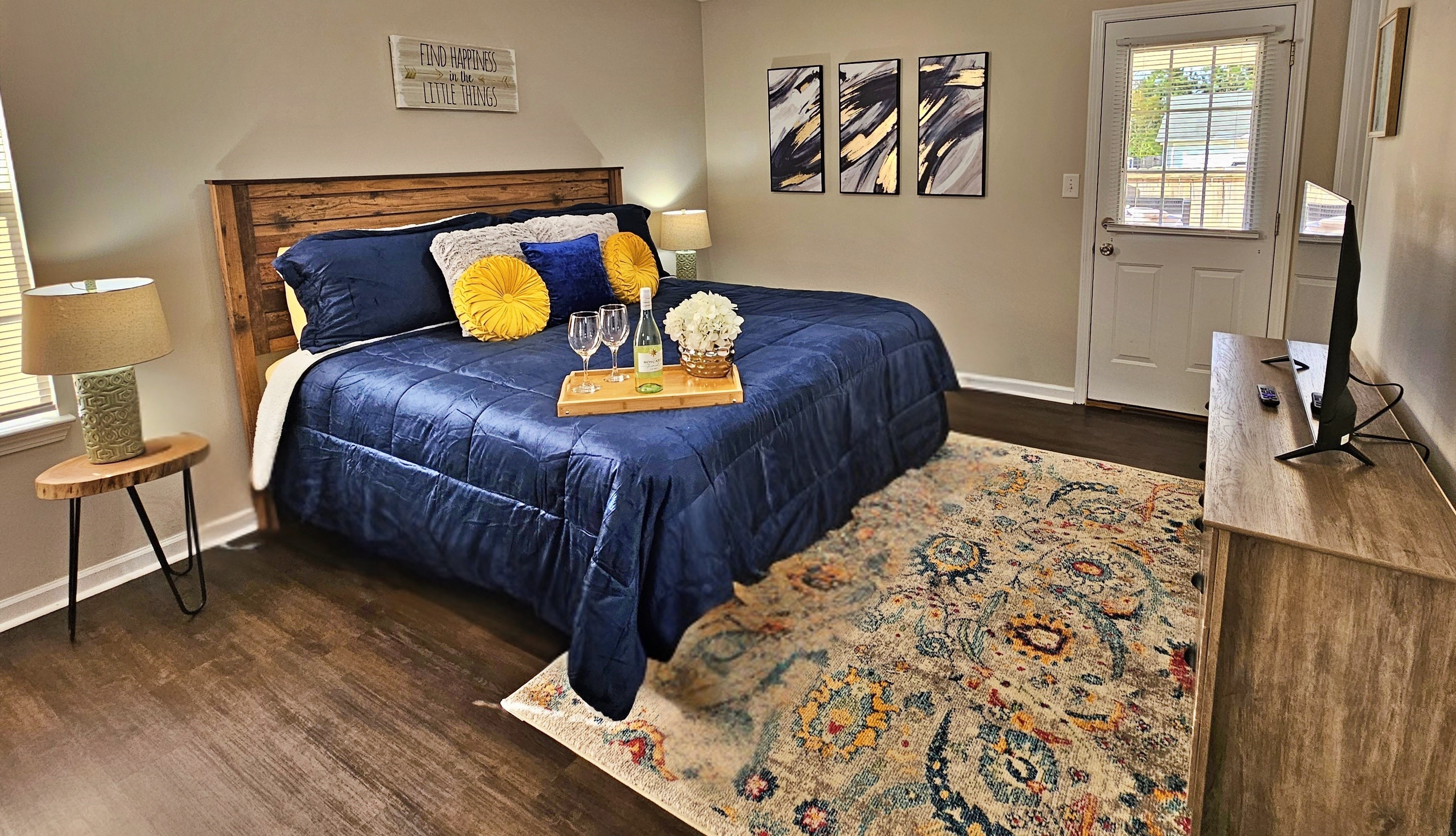 Relax in this farmhouse-style bedroom. There is a king bed along with a flat-screen smart TV. Step out the door to the back patio and fenced-in backyard.