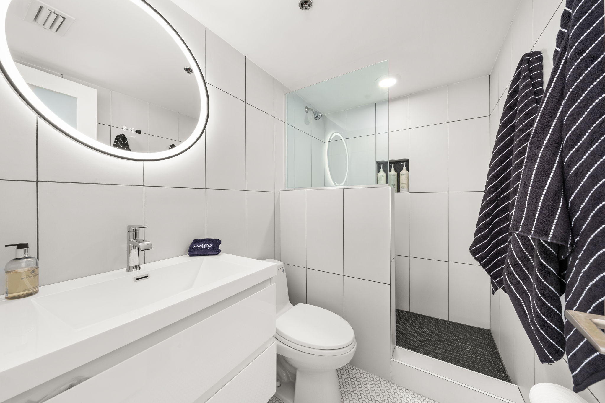 Step into your own spa-like retreat, with a custom walk-in shower, sleek vanity, and a lighted mirror that makes getting ready feel effortless.