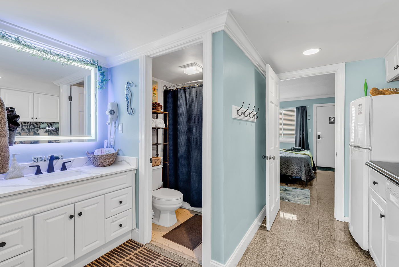 Stylish bathroom with LED-backlit vanity mirror, dual sink, and modern fixtures