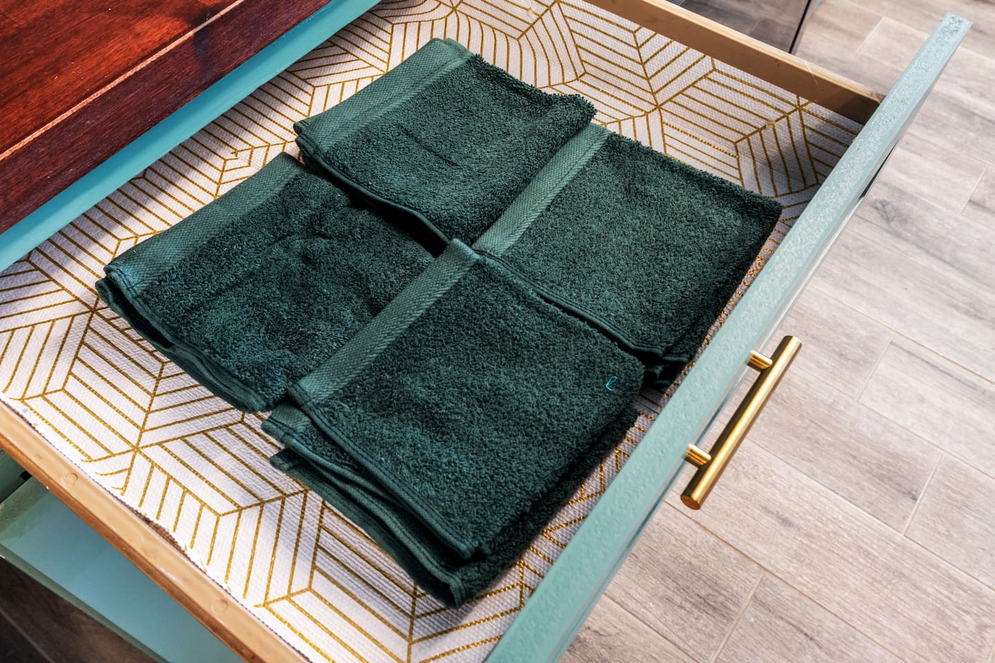 Fresh dark green washcloths are neatly stocked and ready for your stay—luxury meets convenience in every detail.