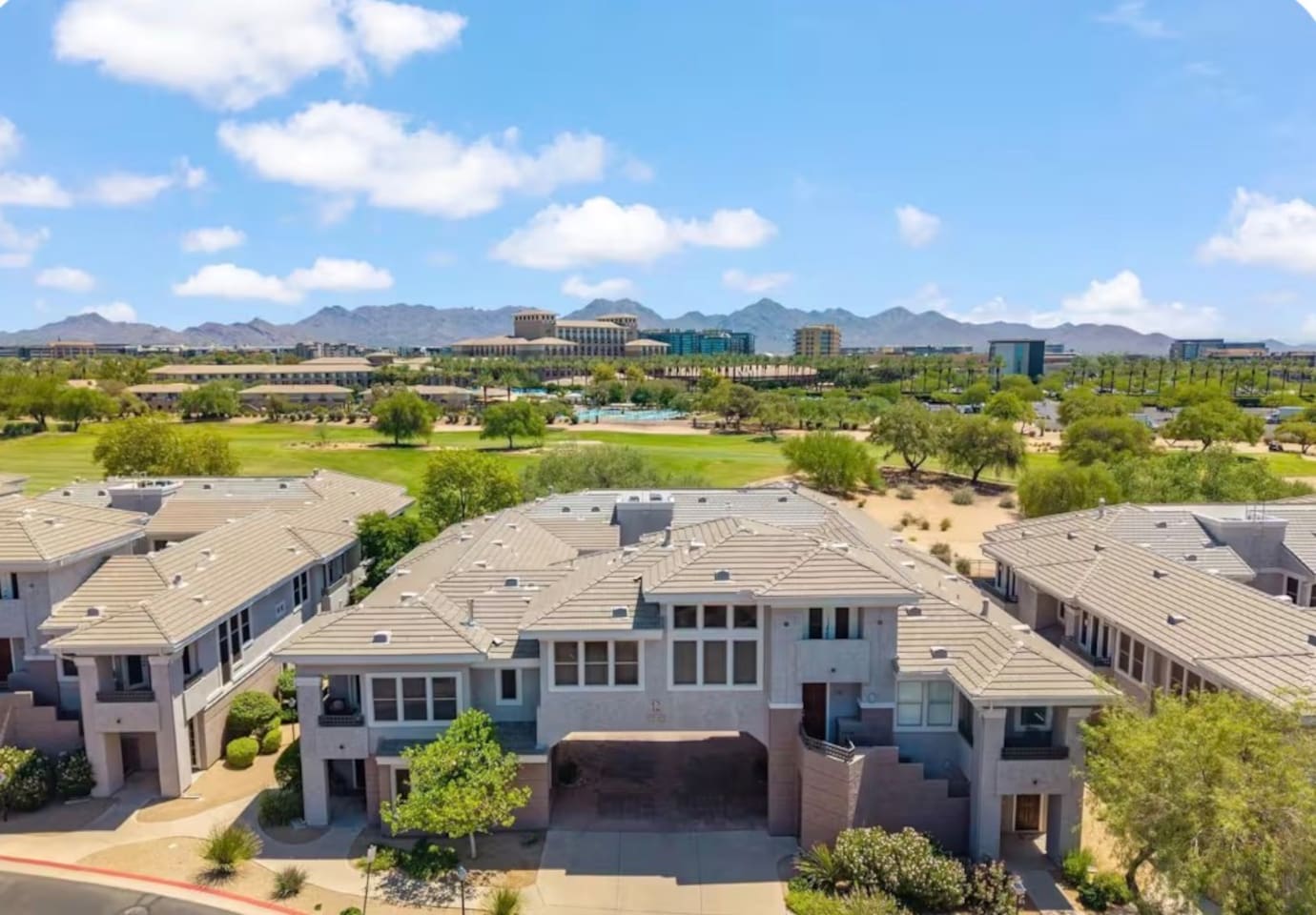 Aerial community view with mountain backdrop, nearby green space, and easy access around the property.