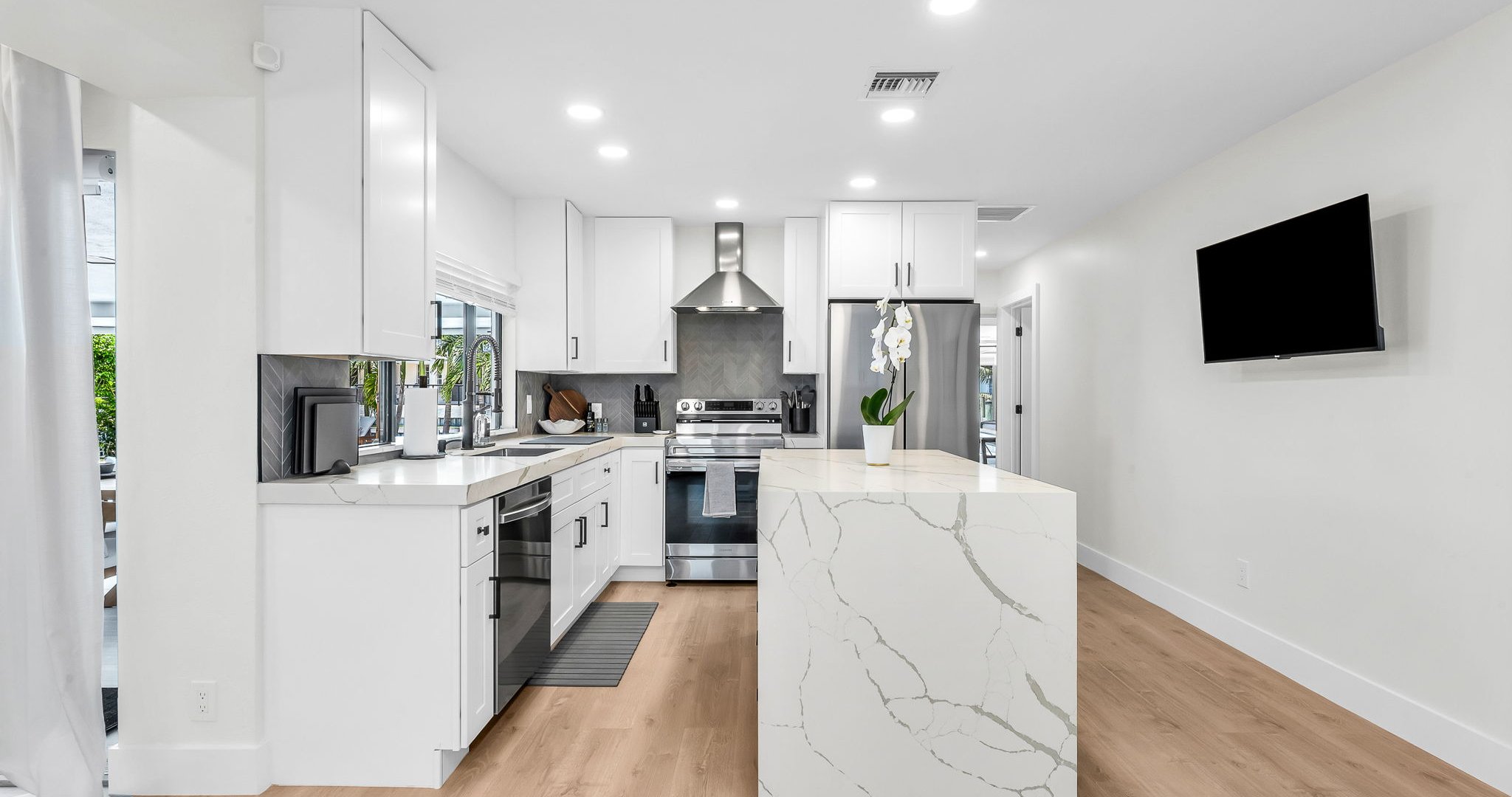 Bright and airy, this modern kitchen combines luxury finishes with everyday comfort. Enjoy the designer backsplash, expansive counter space, and seamless flow to the dining and living areas.