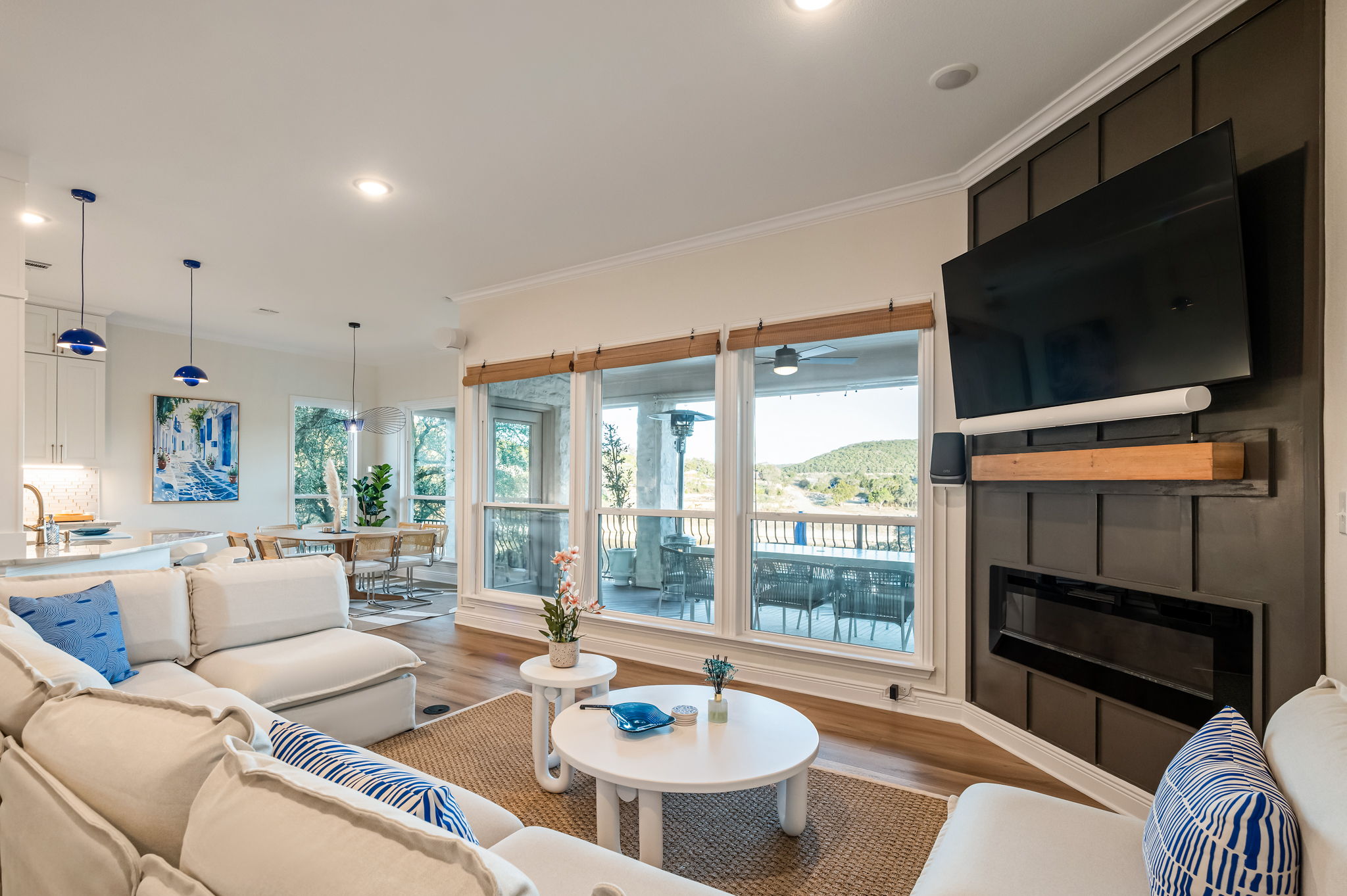 Stunning lakeview living area featuring floor-to-ceiling windows, cozy seating, and a large Smart TV.