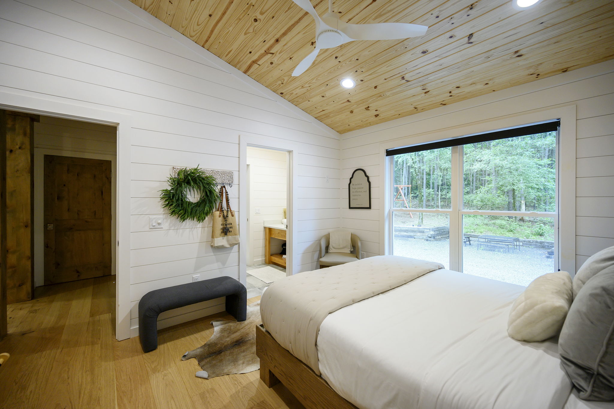 A beautifully appointed queen bedroom featuring luxury design, high-end linens, and peaceful forest views.