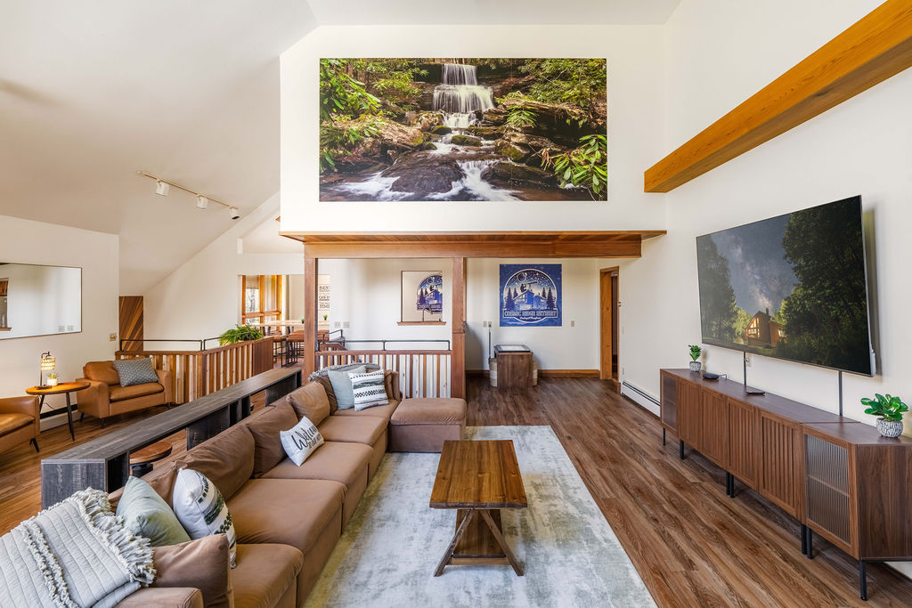 Spacious living room with soaring ceilings, custom artwork, and plenty of seating for your group to gather
