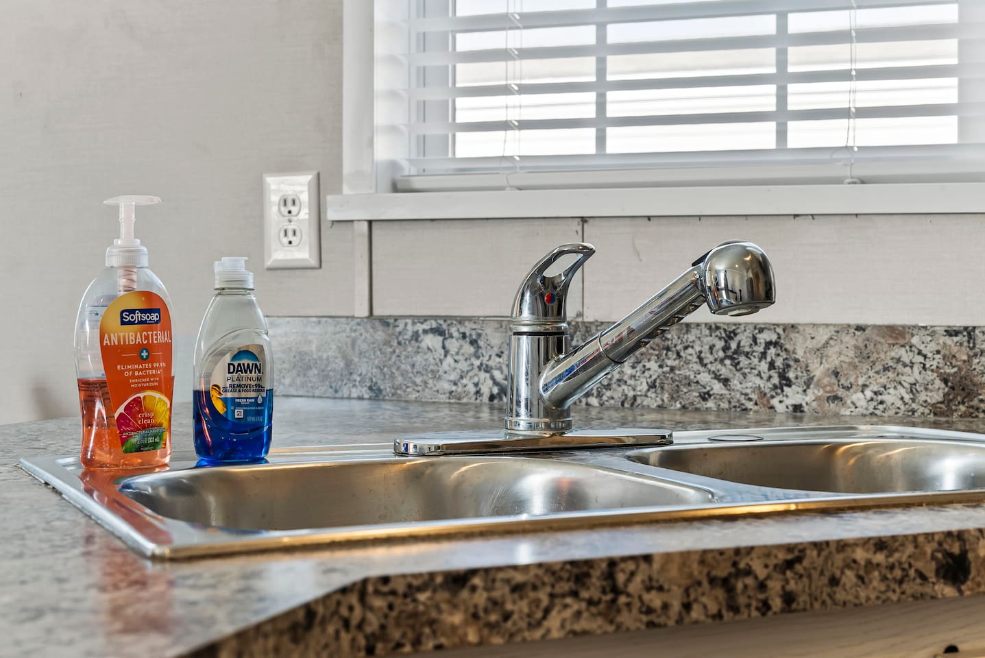 Double sink with modern faucet and cleaning essentials—making kitchen cleanup quick and easy.