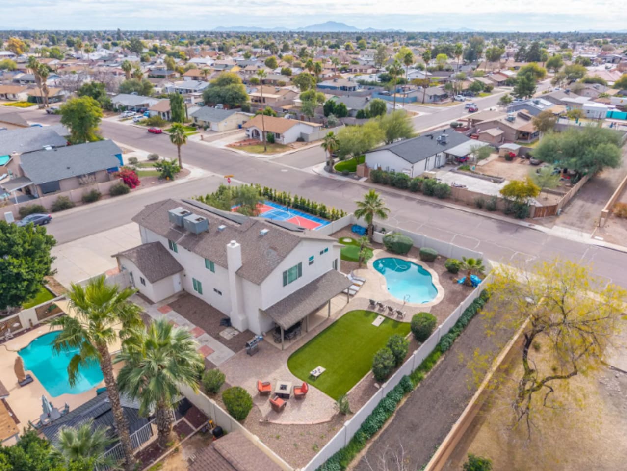 Modern home with resort pool, sports court, and sleek contemporary design in prime neighborhood location.