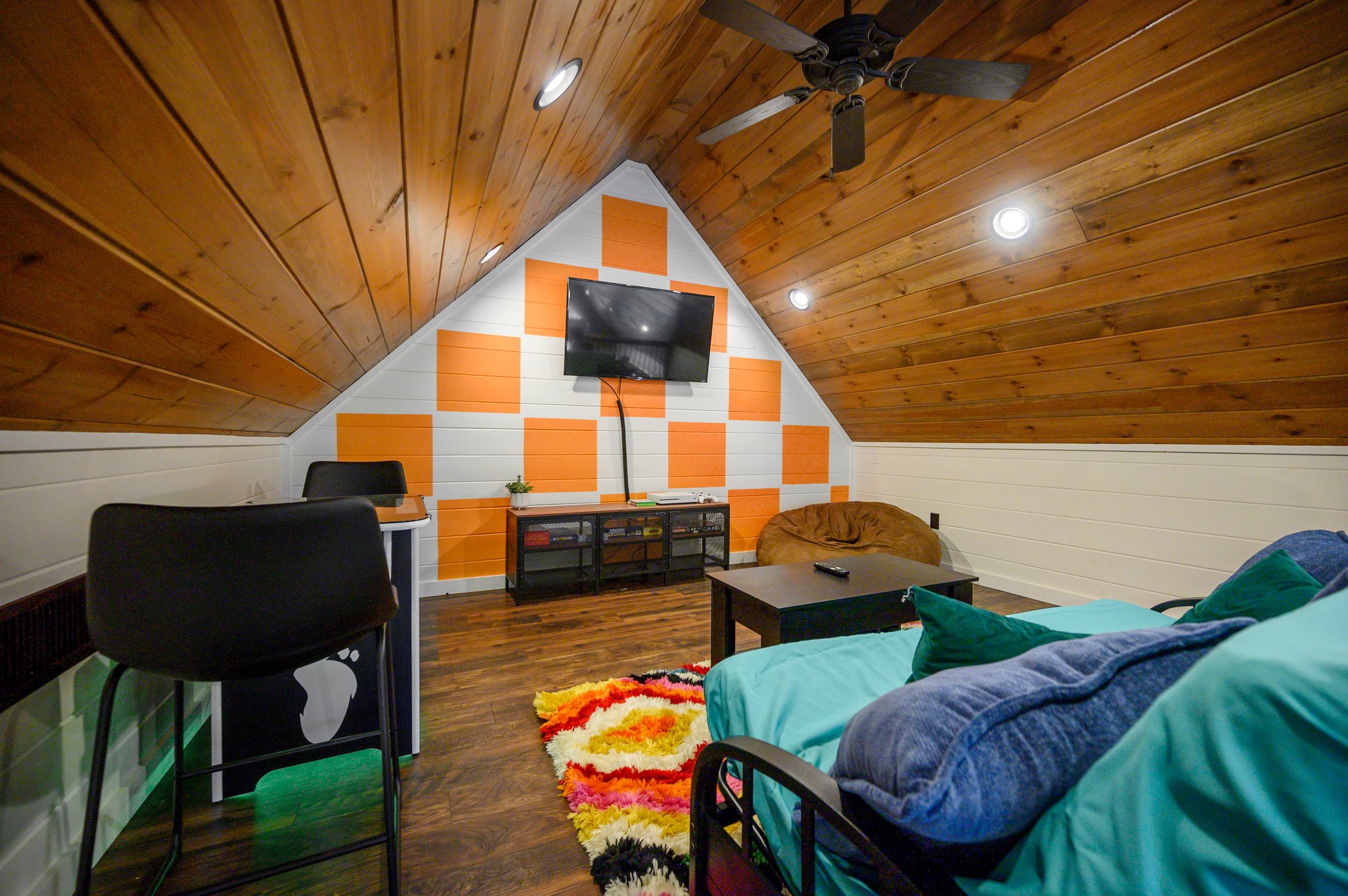 Disco Cowboy | Game loft with air hockey, Xbox and lounge seating. A twin daybed and trundle replaced the old futon; the cabin maximum remains 10 guests, with two king beds and six twin bunks as the advertised sleeping setup.