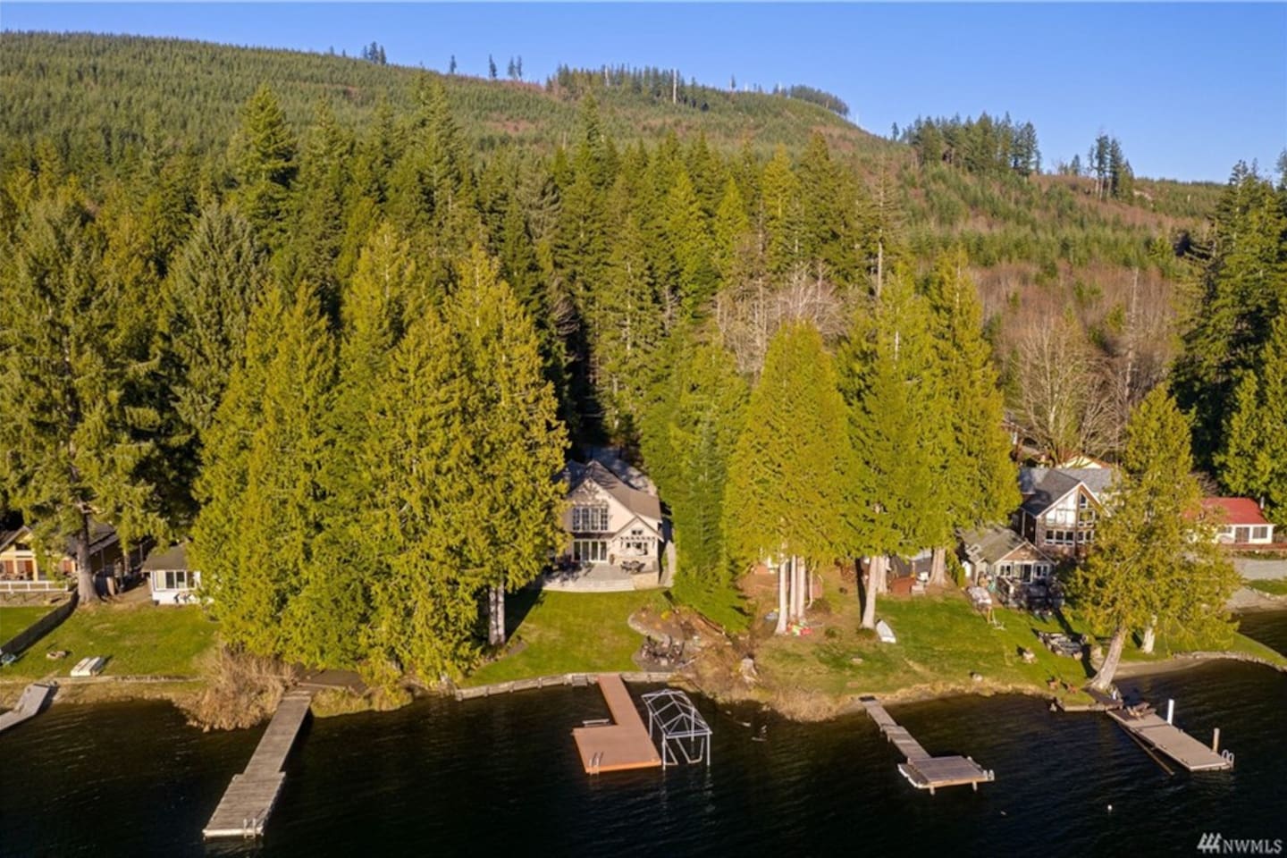 Aerial perspective of the home and lakefront setting.