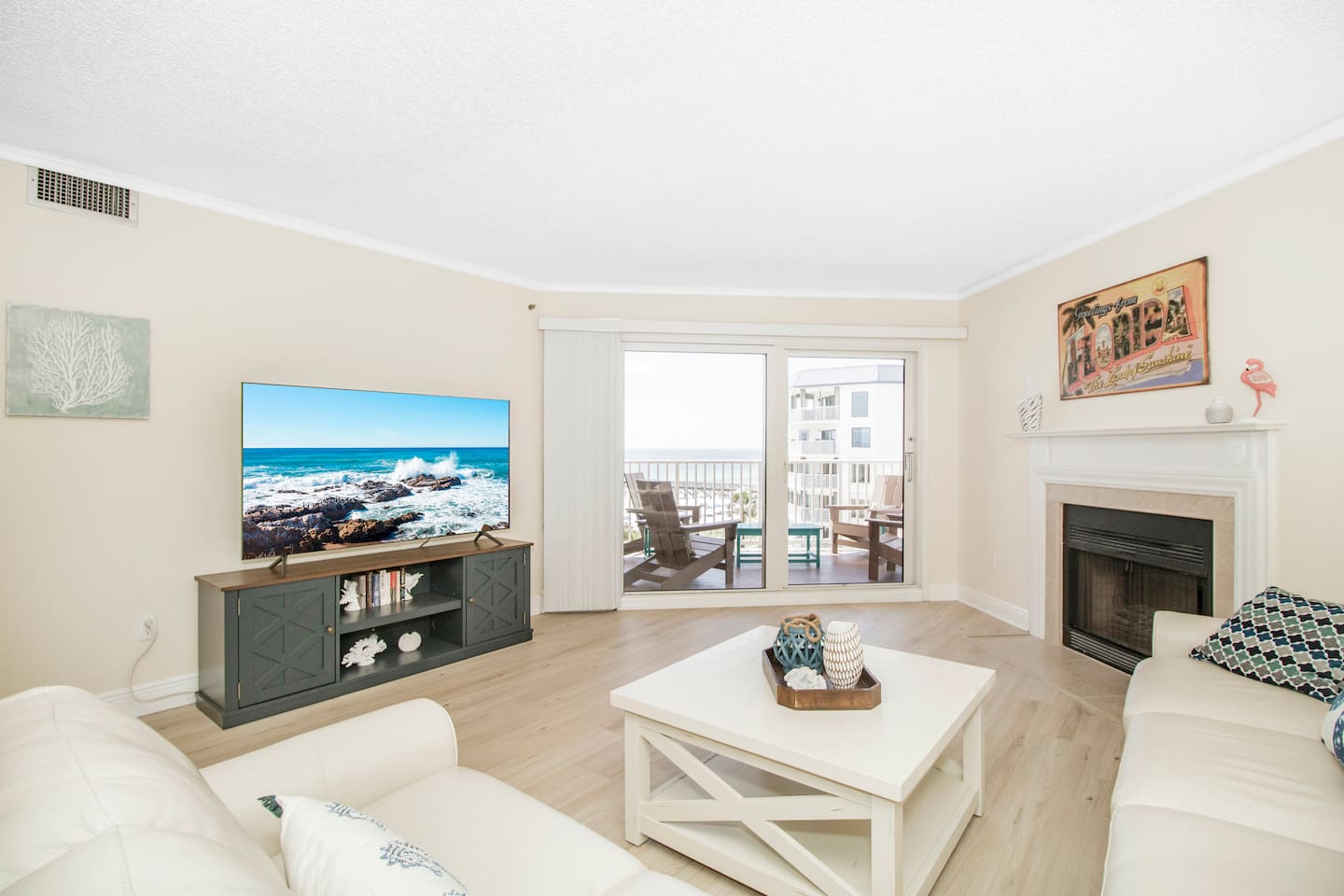 Living room with fireplace, open to the dining and kitchen area with pool and gulf views. 