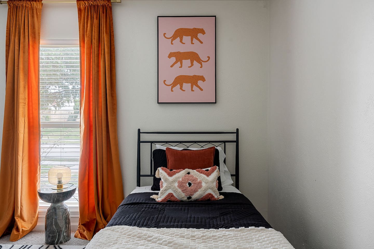 Enjoy the appeal of this tiny room, which includes distinctive wall art and a comfortable single bed. Natural light enters through the huge window.