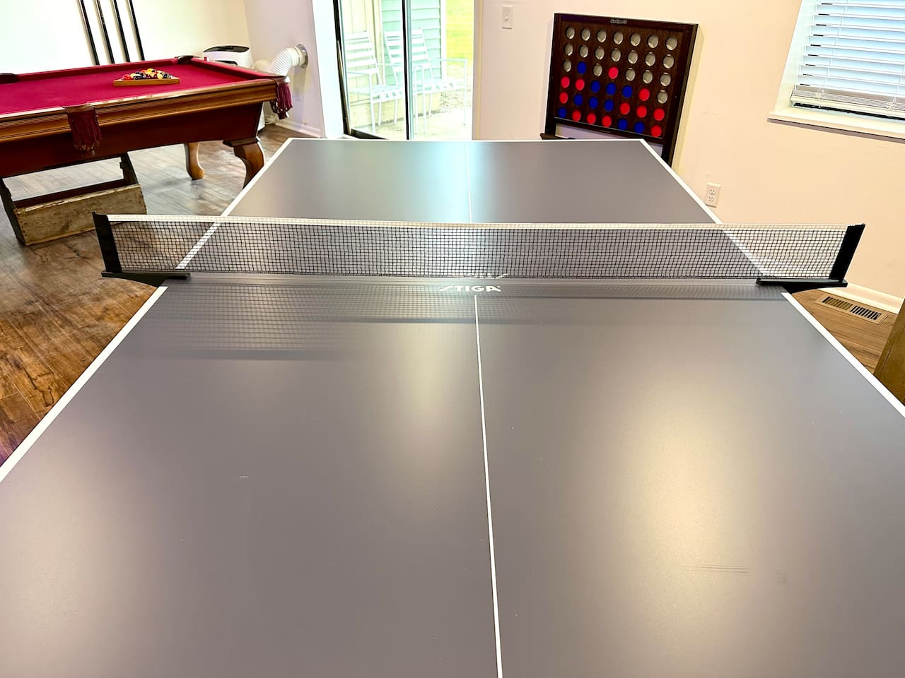Spacious shared game room with pool table, ping pong, Connect 4, TV, board games and casual seating—perfect for relaxing or friendly competition after a day of adventure. Great for groups and families looking for fun during their stay!