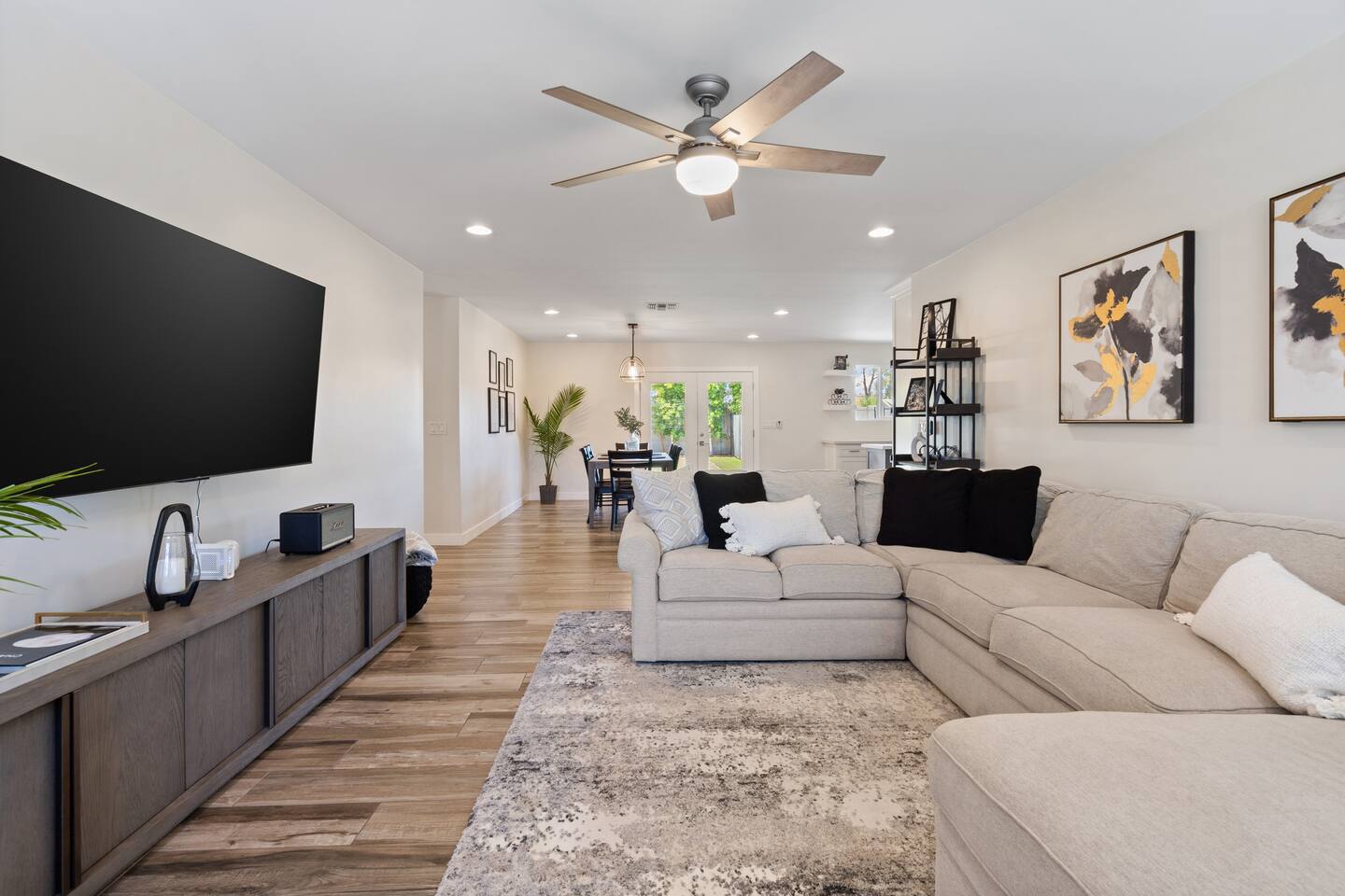 Open living room with large sectional seating, ceiling fan, perfect for gathering!