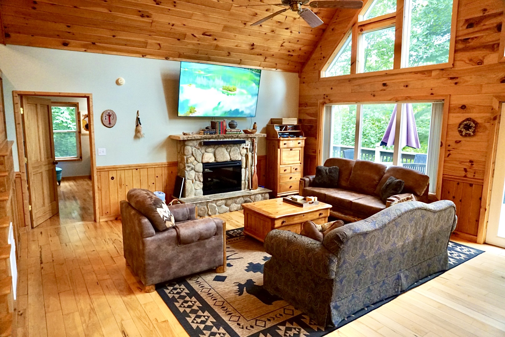 Living Room: Spacious haven with natural light, stone fireplace, and comfy seating for relaxation!