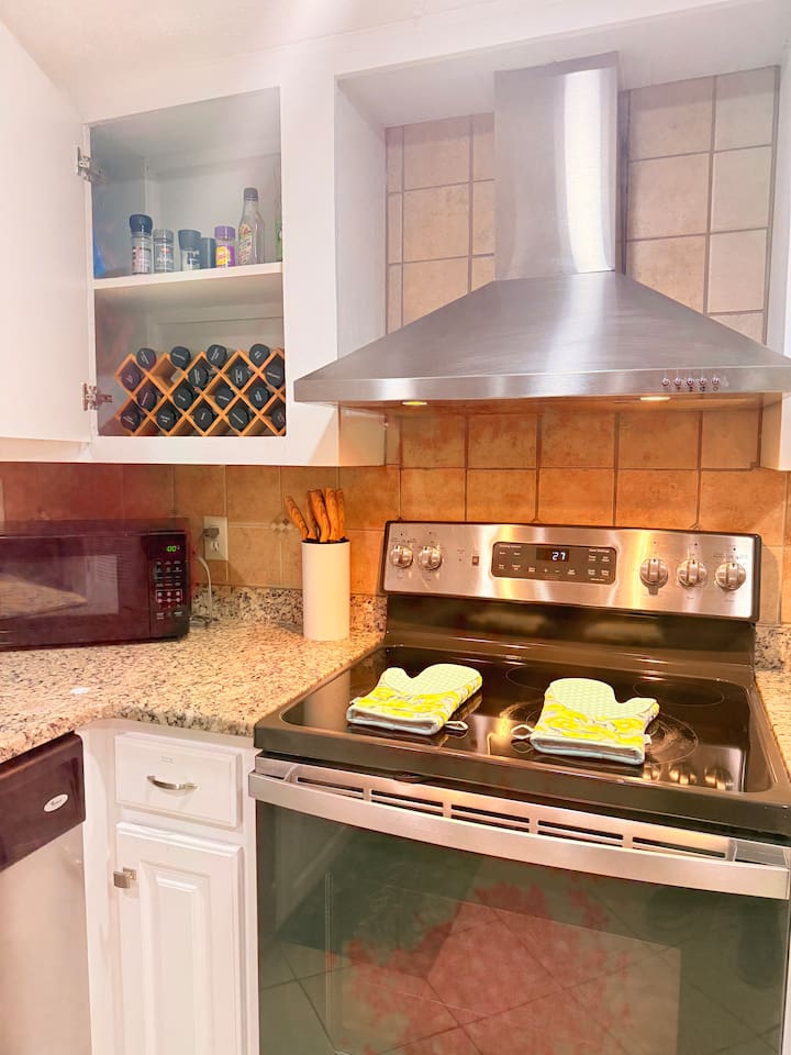 Stainless stove and stocked cookware make meal prep easy, whether you’re cooking for two or a group. 