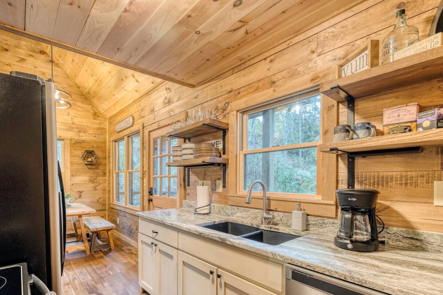 Our pristine kitchen area showcases the cabin's modern amenities, inviting you to create culinary delights amidst the beauty of nature, where comfort and convenience harmonize seamlessly