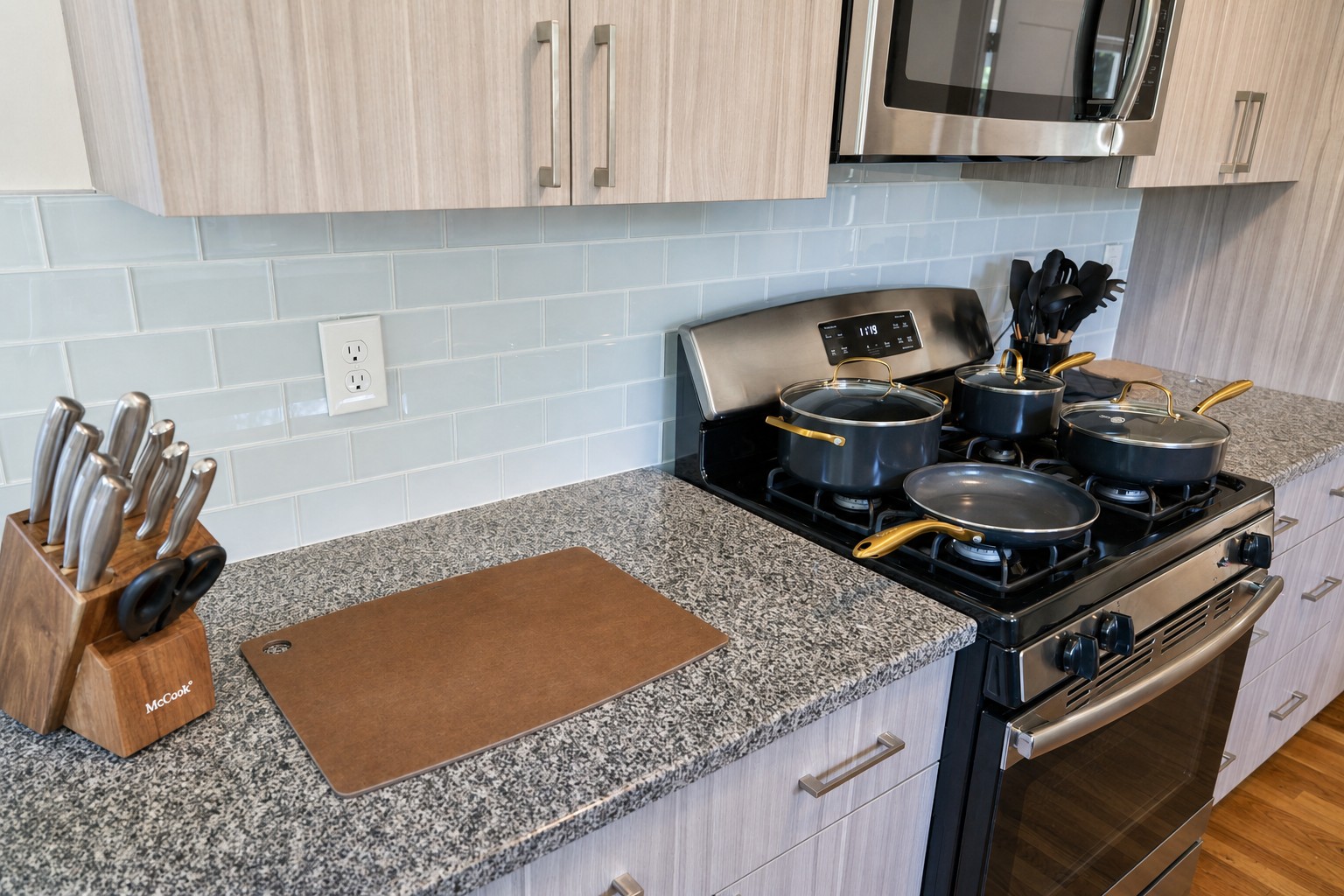 Gas range with a full set of pots and pans, a knife block and a cutting board