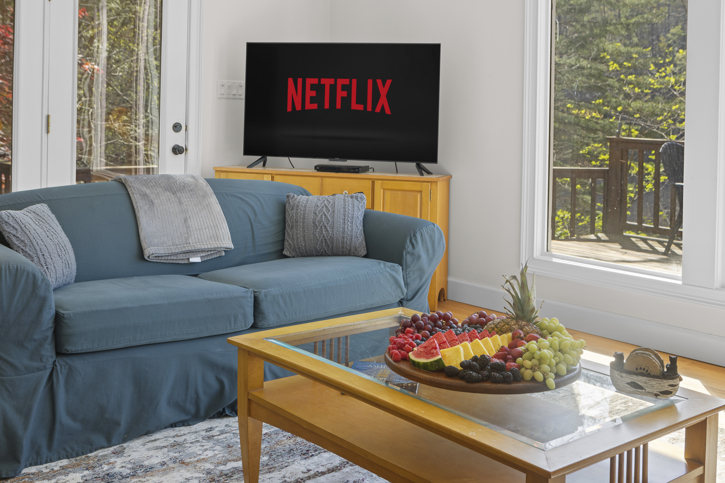 Living Area: Relax in bright space with Netflix, fresh fruit, and scenic deck views!