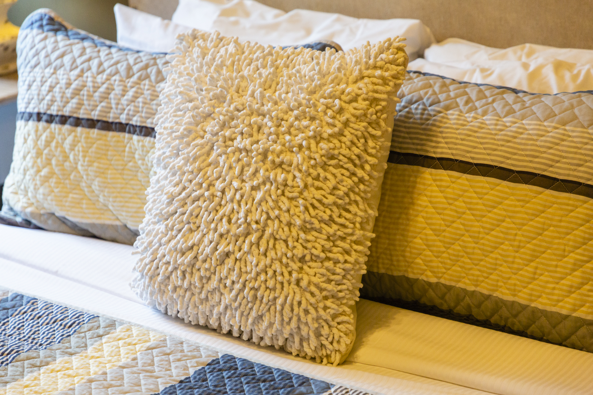 Soft textures and layered pillows create an inviting touch of comfort.