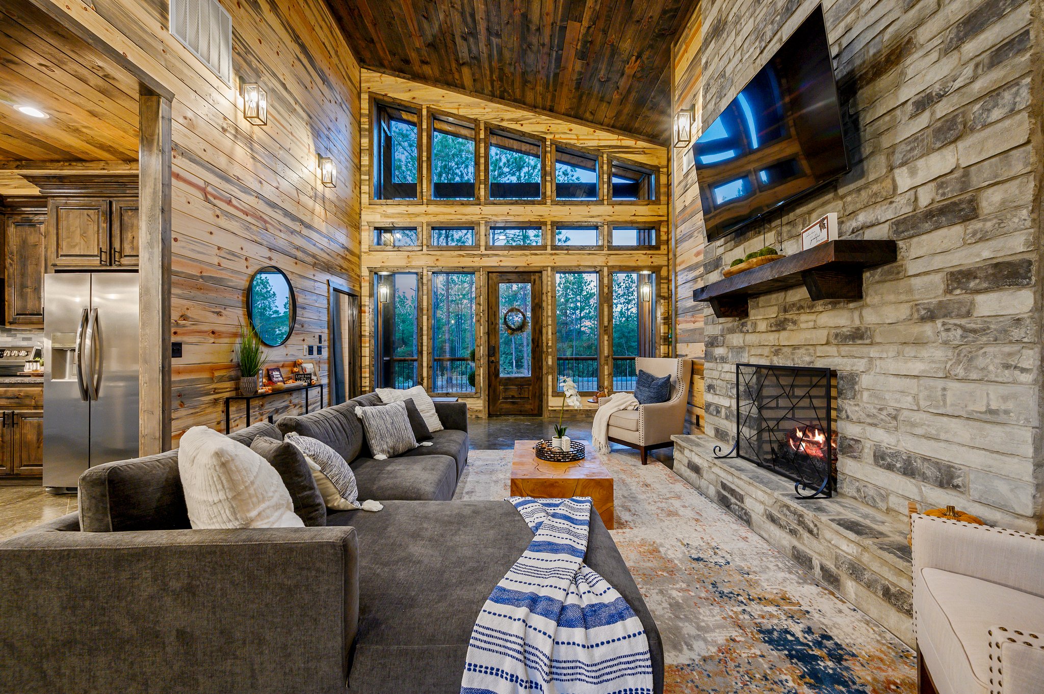 Sun-drenched living with soaring ceilings and a cozy stone fireplace.