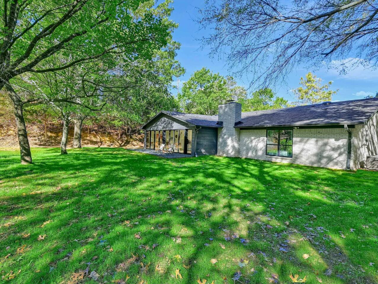 Backyard view showing open green space, tree canopy, and peaceful natural surroundings ideal for outdoor relaxation.