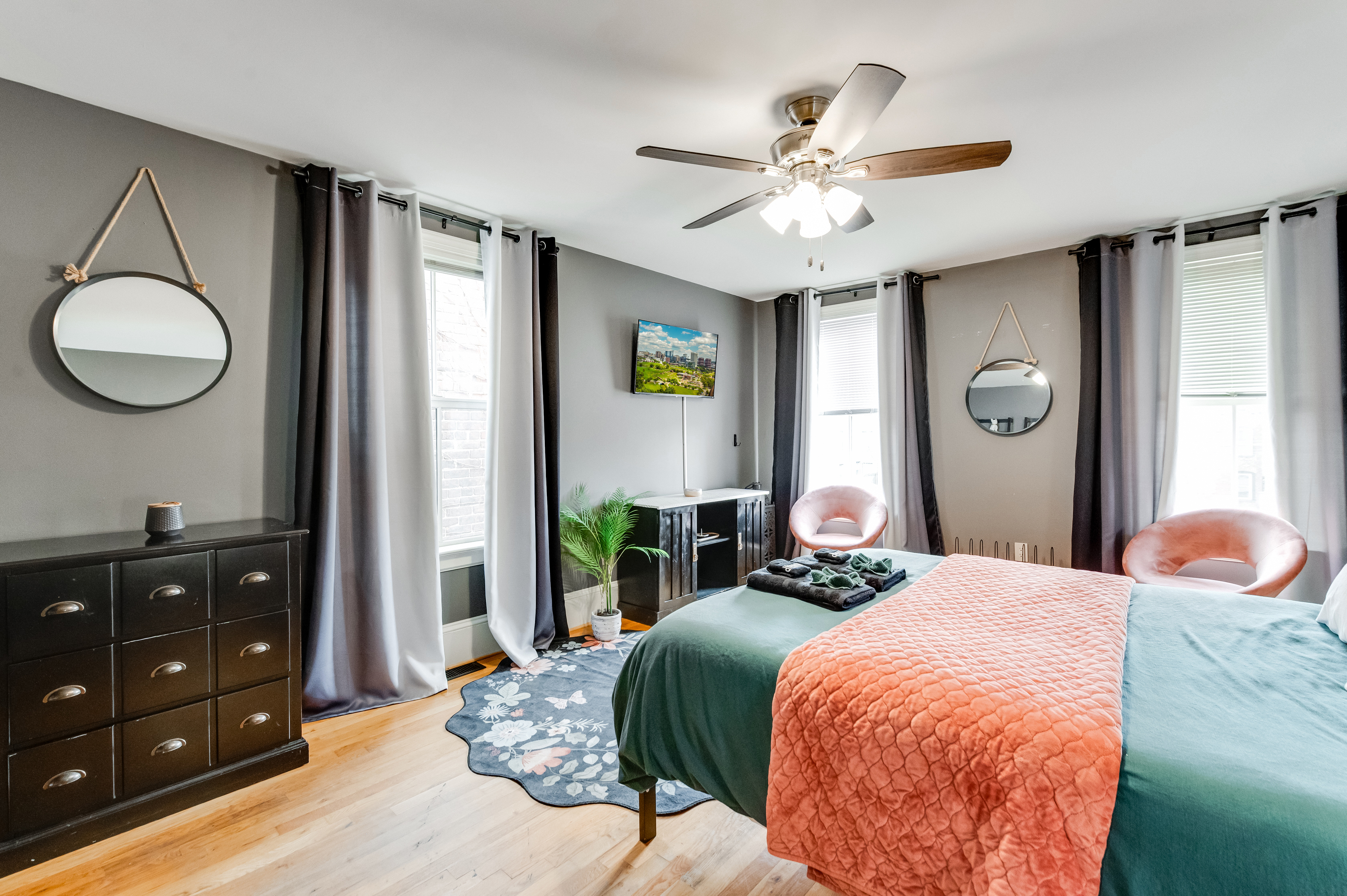 Queen Bedroom 3: Stylish decor and bright windows create an inviting ambiance for relaxation.
