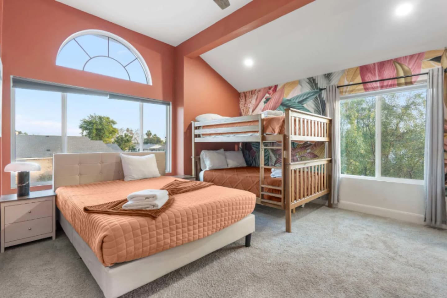 Bright, cheerful kids' bedroom with queen bed, bunk beds, and plenty of natural light for family groups.