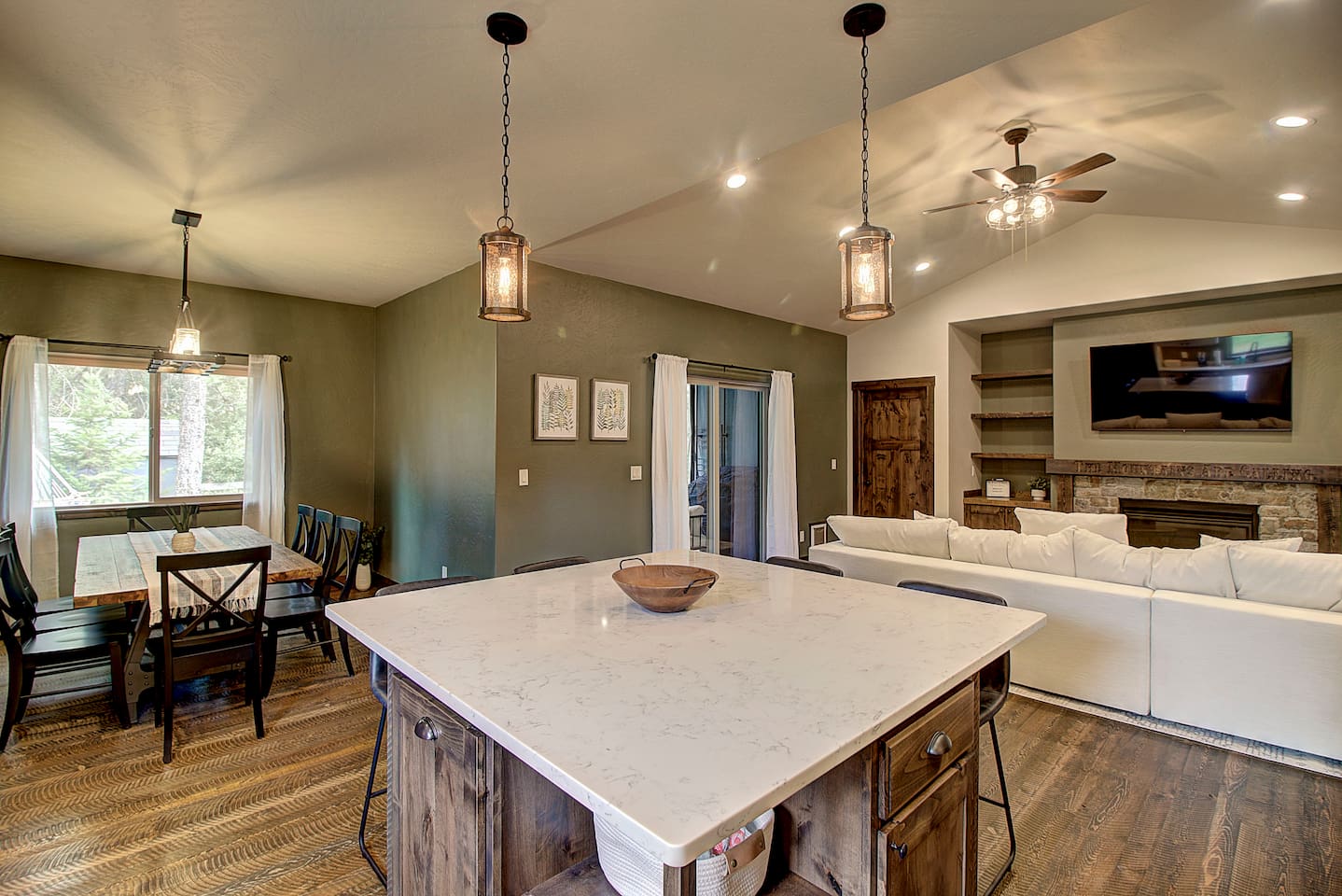 Dining area with large windows offering natural light and views of the surrounding trees.