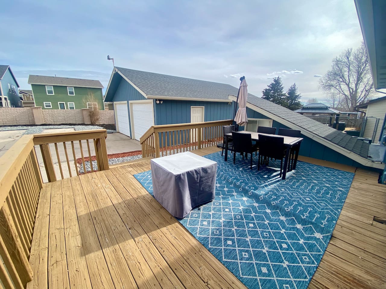 Private, fully-fenced backyard with fire pit, grill, and dining table.
