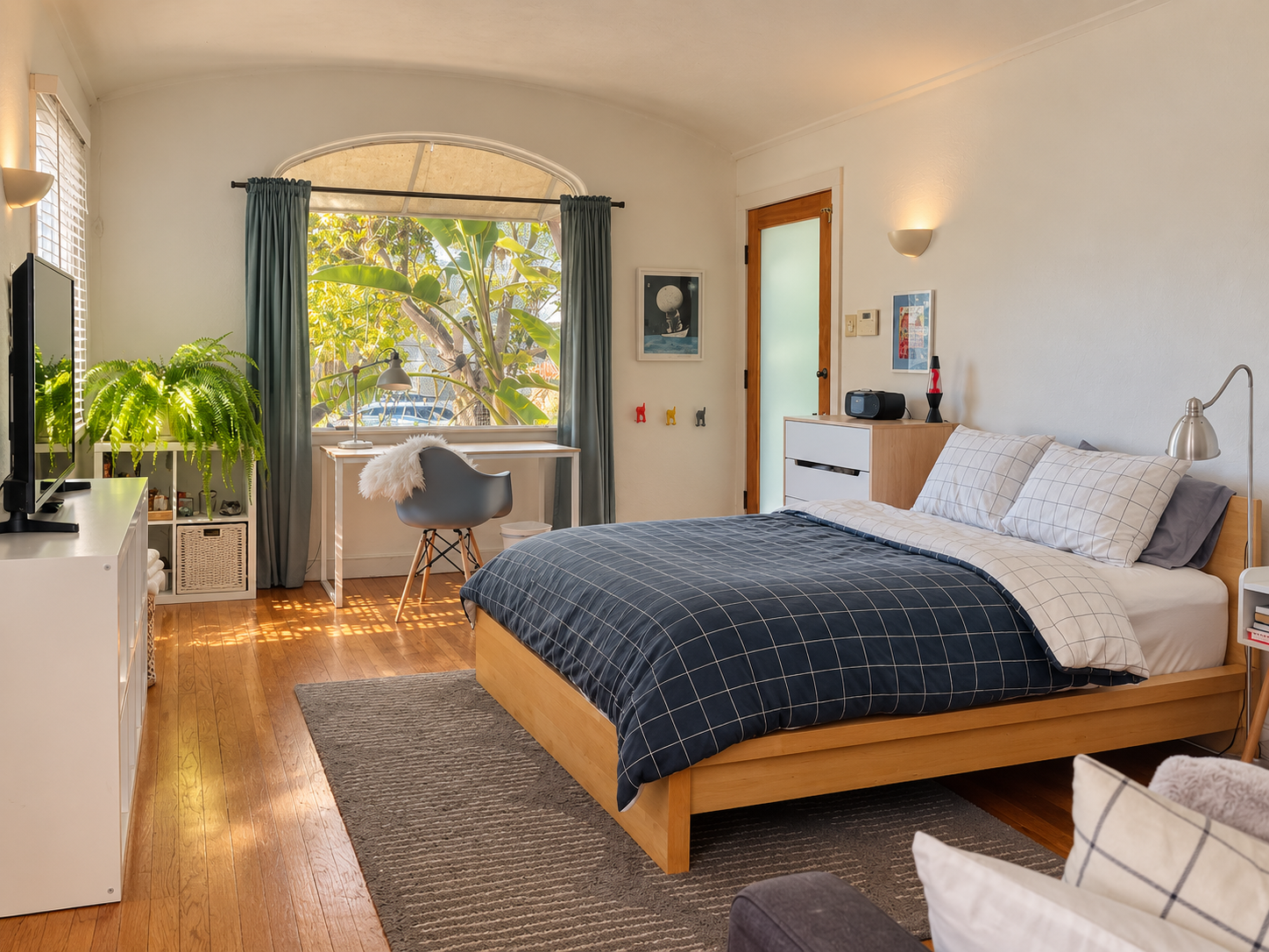 Bedroom with an arched window and writing desk.