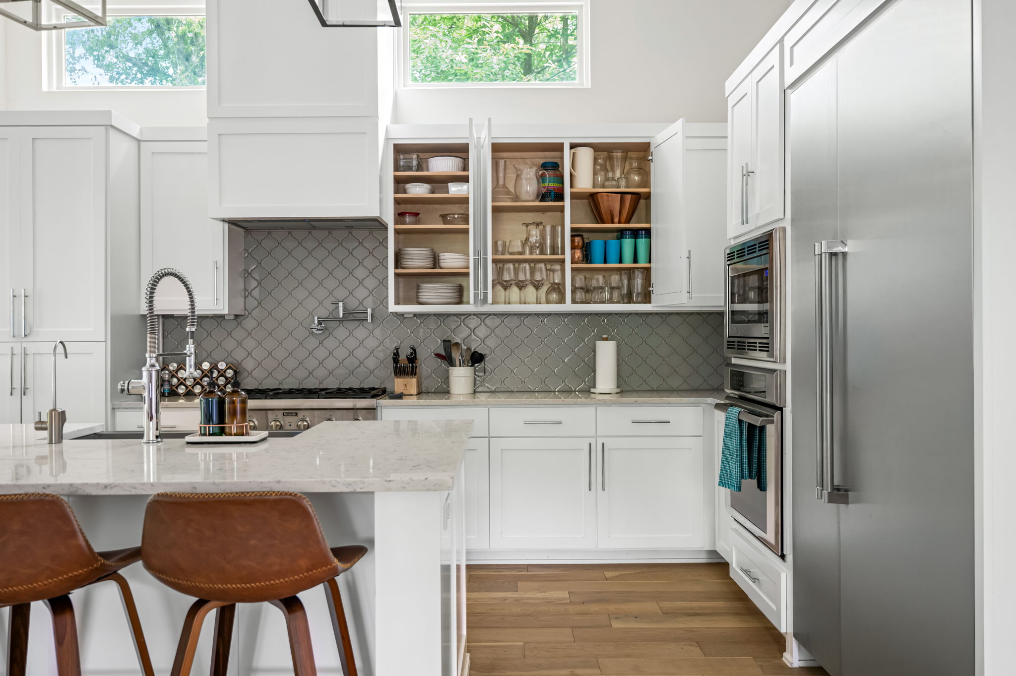 Well-appointed kitchen corner with a prep sink, open shelving, and pantry storage — functional design meets modern style.