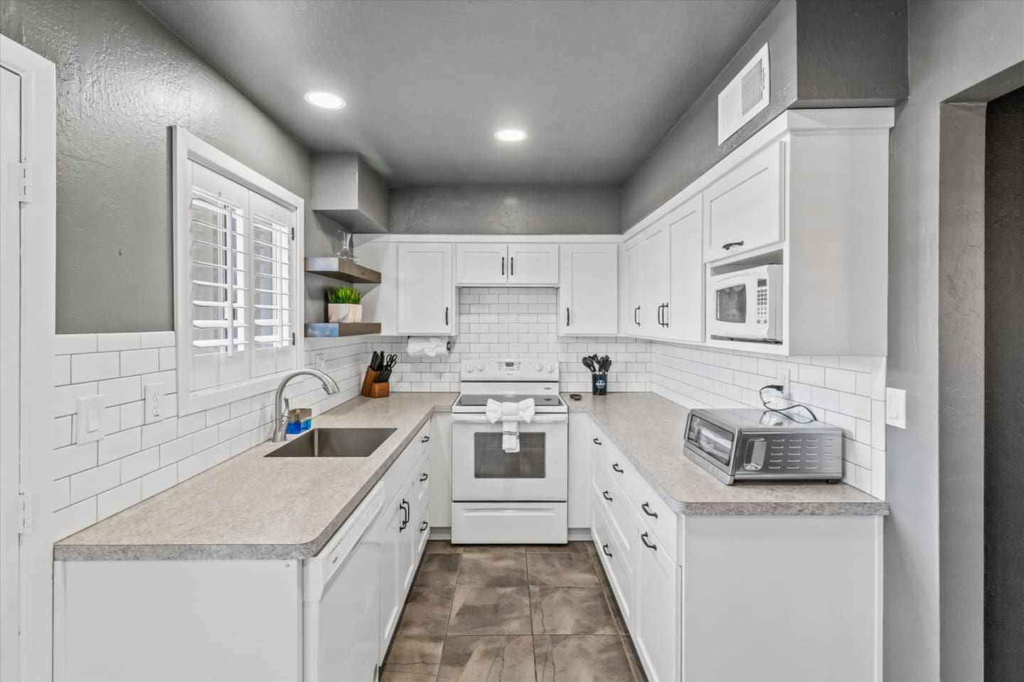 Kitchen with white cabinets, full appliances, and plenty of counter space for easy meals.