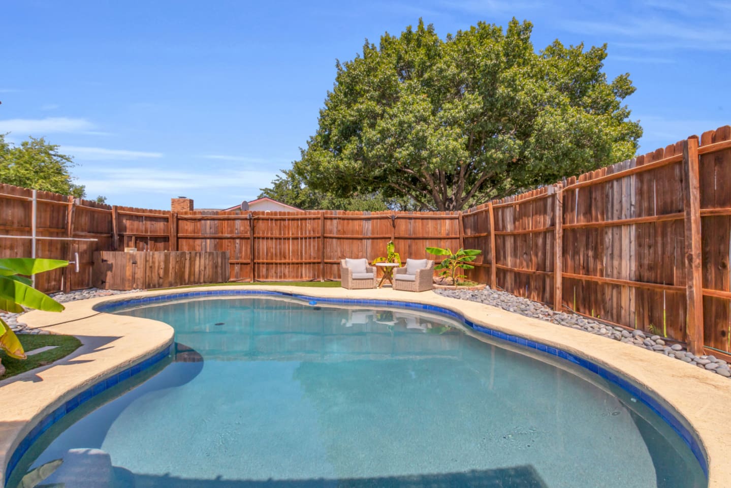 Dive into relaxation. This spacious fenced backyard with a private pool and lounging areas.
