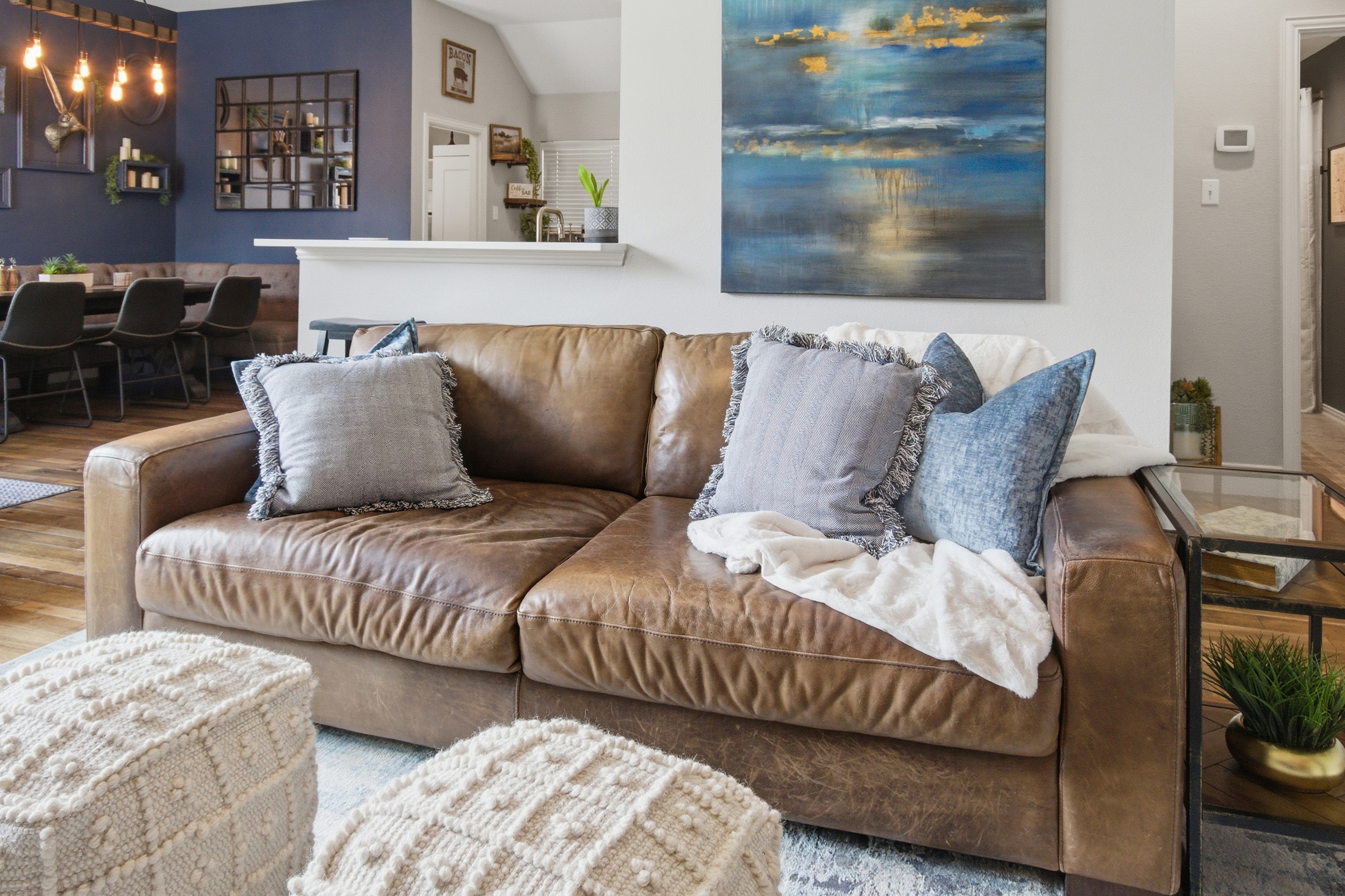 Comfortable Living Room sofa stacked with pillows and blankets, perfect for movie nights with the 65-inch Smart TV and streaming.
