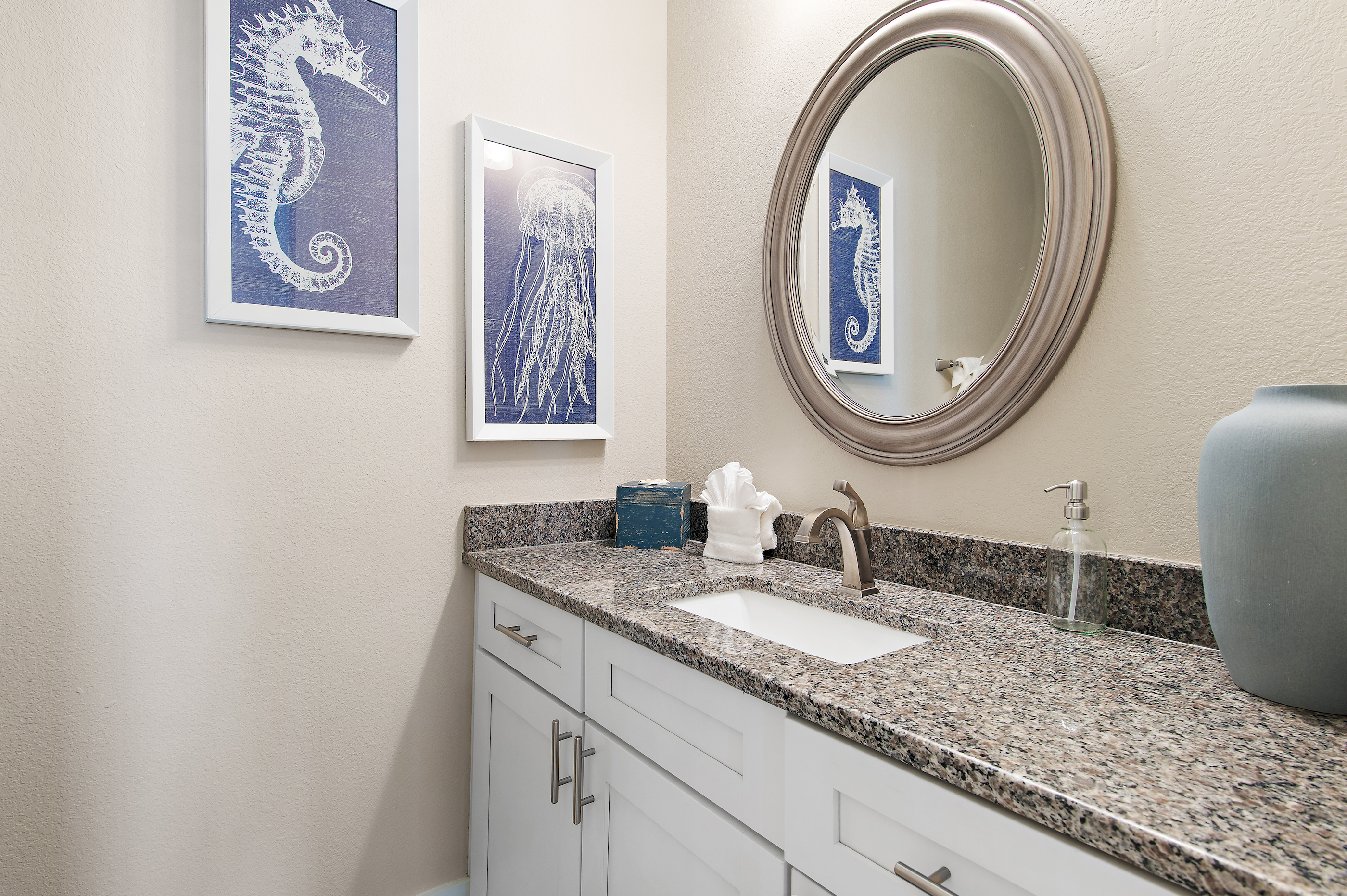 Bright, spacious bathroom with a walk in shower, generous vanity, and elegant coastal details.
