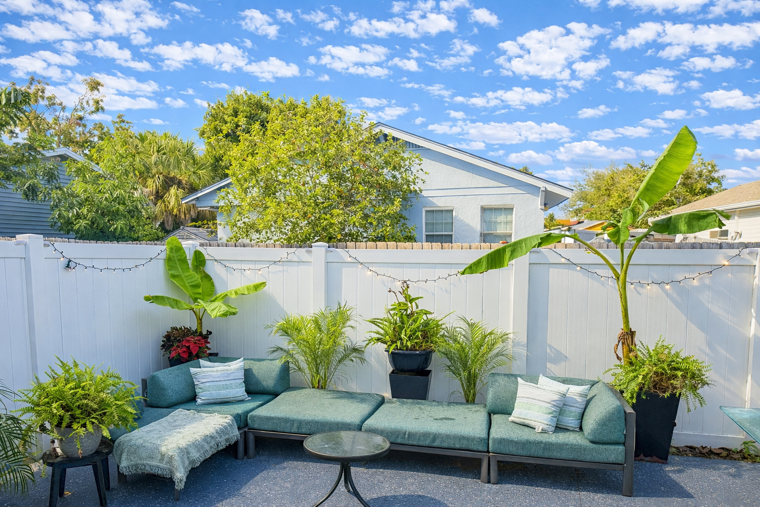 Modern indoor-outdoor living room: open-plan design seamlessly integrates with nature. Features large glass French doors, comfortable furnishings, and a natural palette, ideal for relaxation