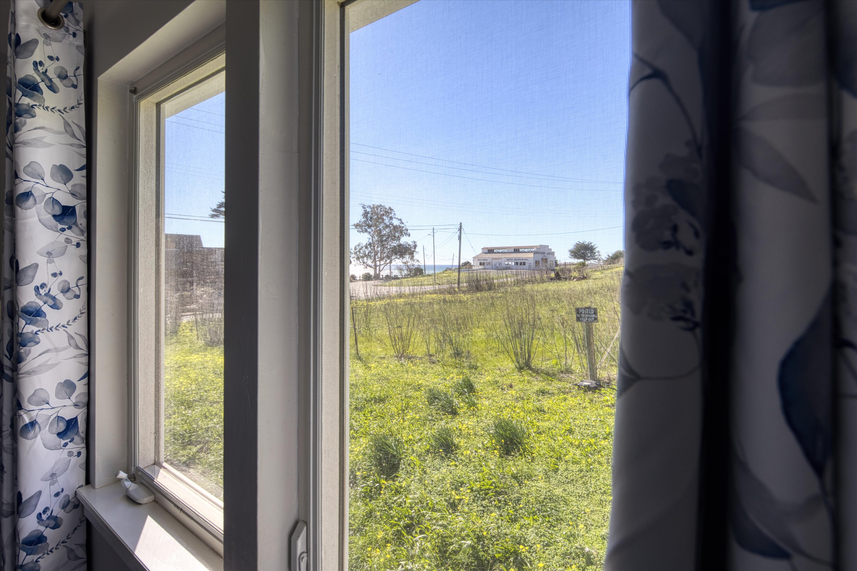 Wake up to views of the hillside and watch sunsets over the ocean from the views in this bedroom