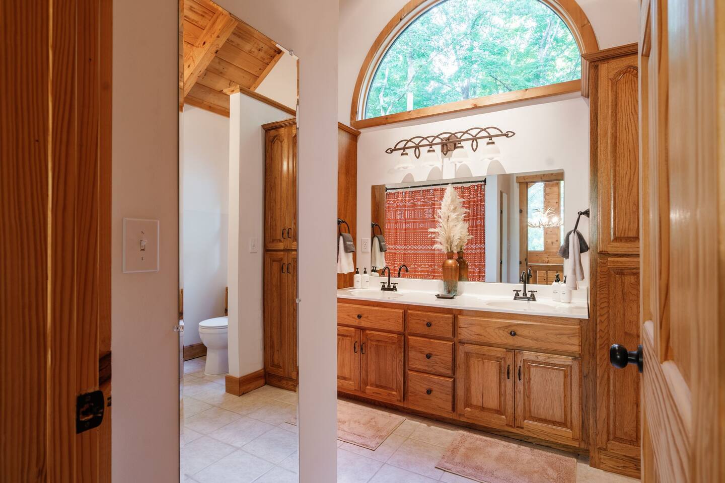 Large upstairs bathroom with double vanity and shower tub combo.