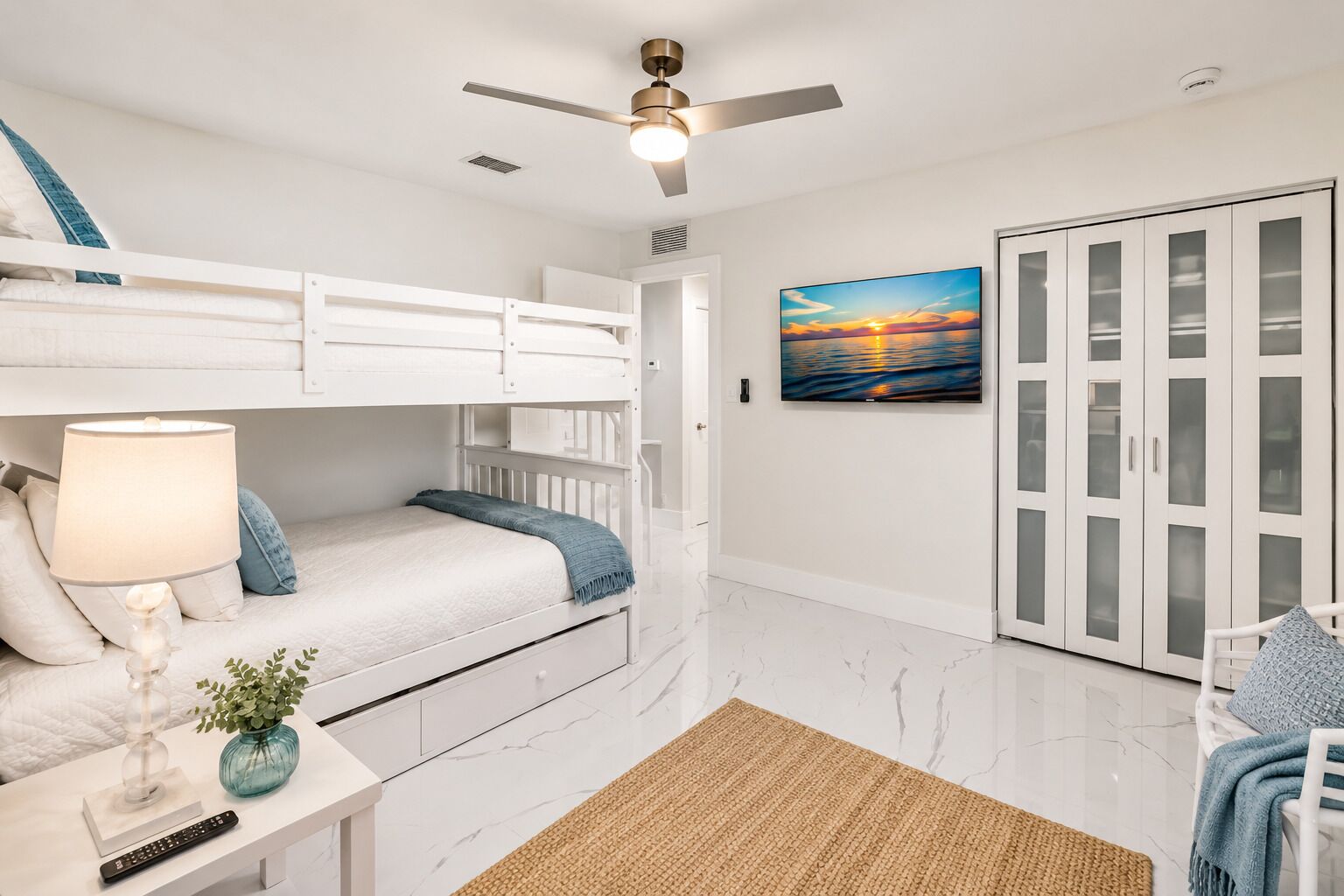 Family-friendly bedroom featuring a triple double-over-double bunk bed, TV, ample storage, and its own private bathroom.