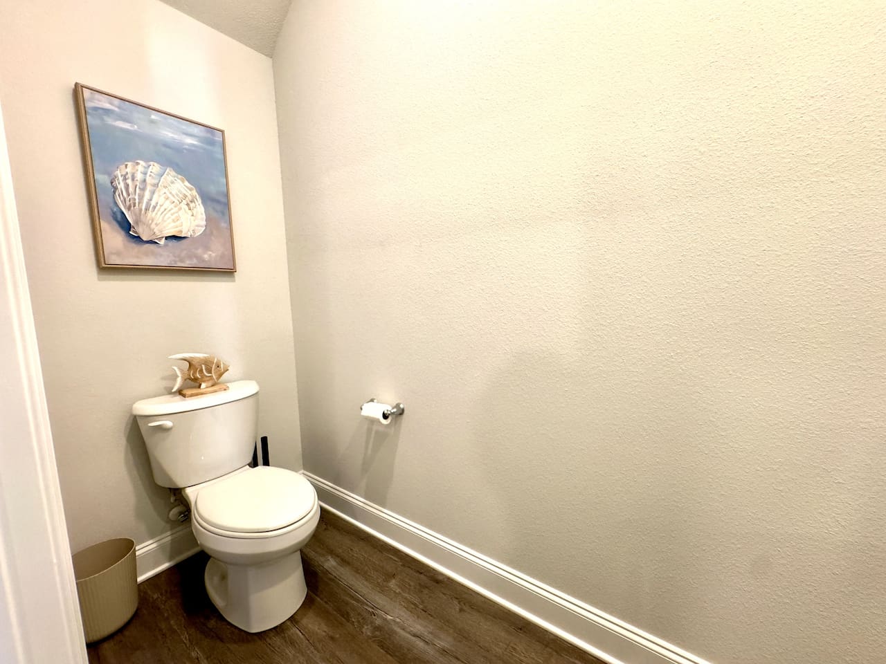 Tucked-away and quiet, wood floor cool underfoot. Coastal artwork catches your eye, a moment of calm privacy.