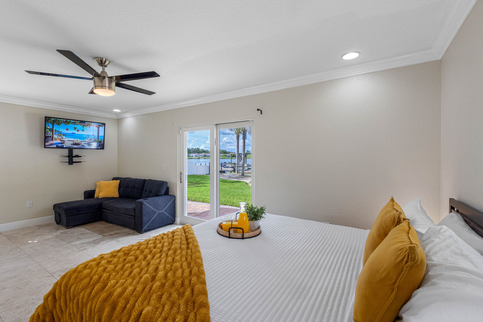 Wake up to serene water views in this airy bedroom, featuring sliding glass doors that open directly to the lush backyard and waterfront.