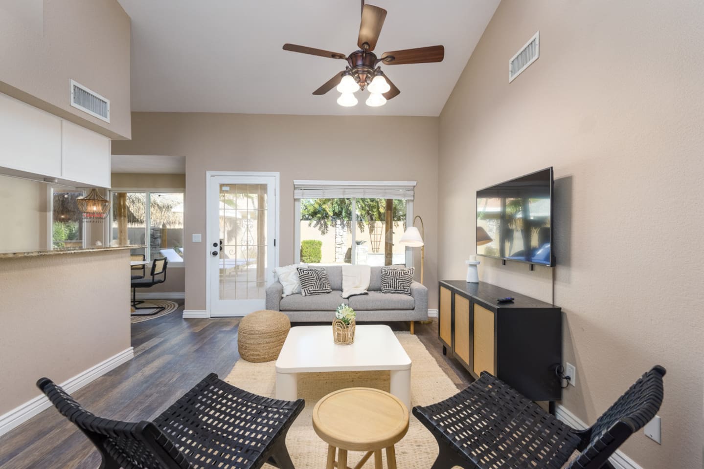 Sitting area with wall-mounted TV, comfortable seating, ceiling fan, and patio door access for relaxed downtime.