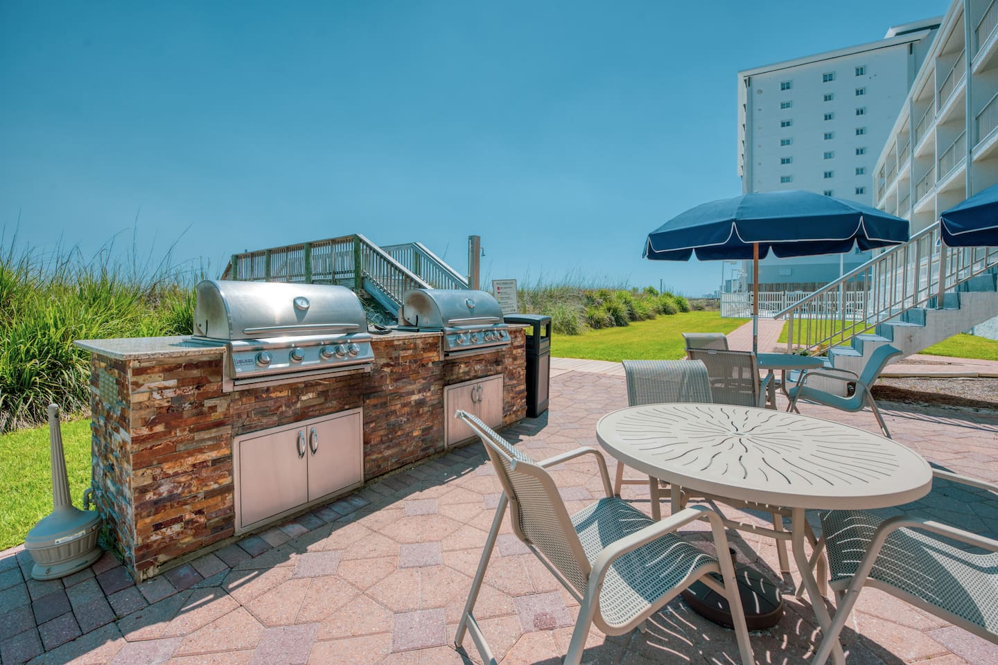 Shared beachfront gas grills for meals by the Gulf.