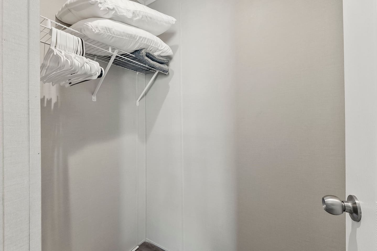 Simple closet space with hangers and extra linens, giving you practical storage during your stay.