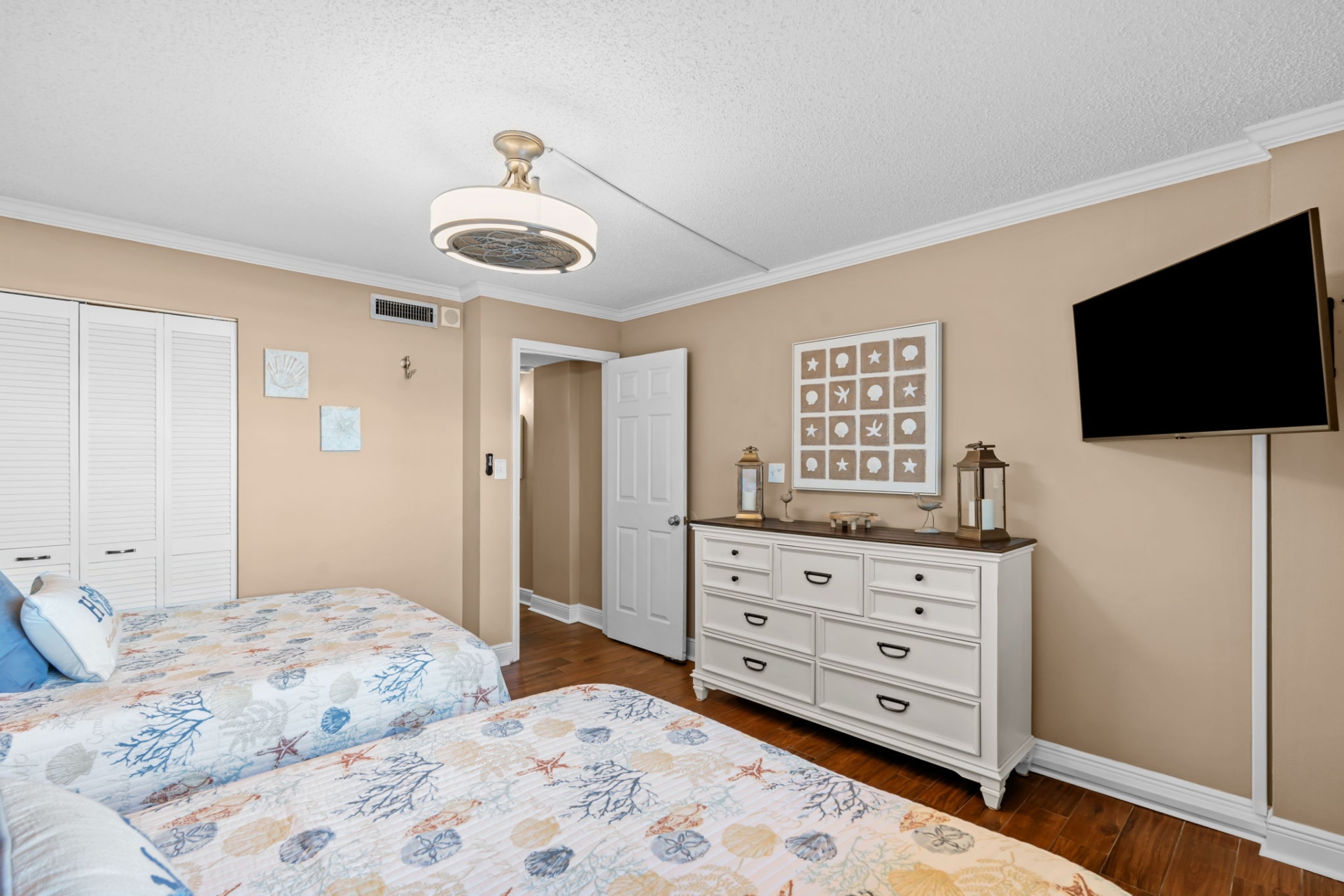 Guest bedroom with two full beds, smart TV and clothing storage