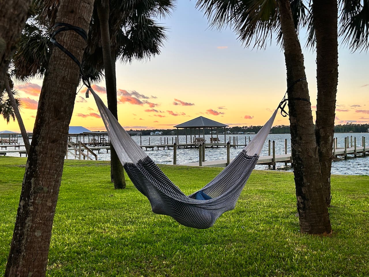 Serene lakeside hammock at sunset with tranquil views and peaceful vibes.