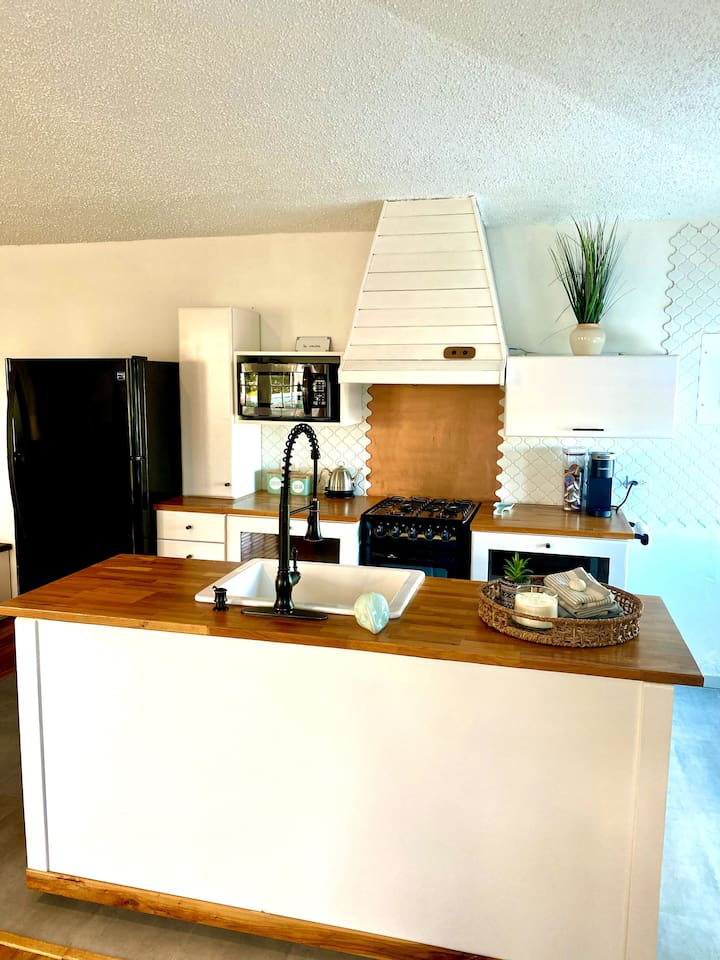 This is a view of the Coral Suite Kitchen. Stove(small but capable), hood with exhaust, microwave, nice size fridge(probably larger than you need). And everything else you need to cook and enjoy your stay.